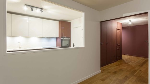 Entrée et cuisine vues depuis le séjour. Le rouge BORDELAISE de l’entrée fait écho au FENIX ROSSO des façades de portes de cuisine